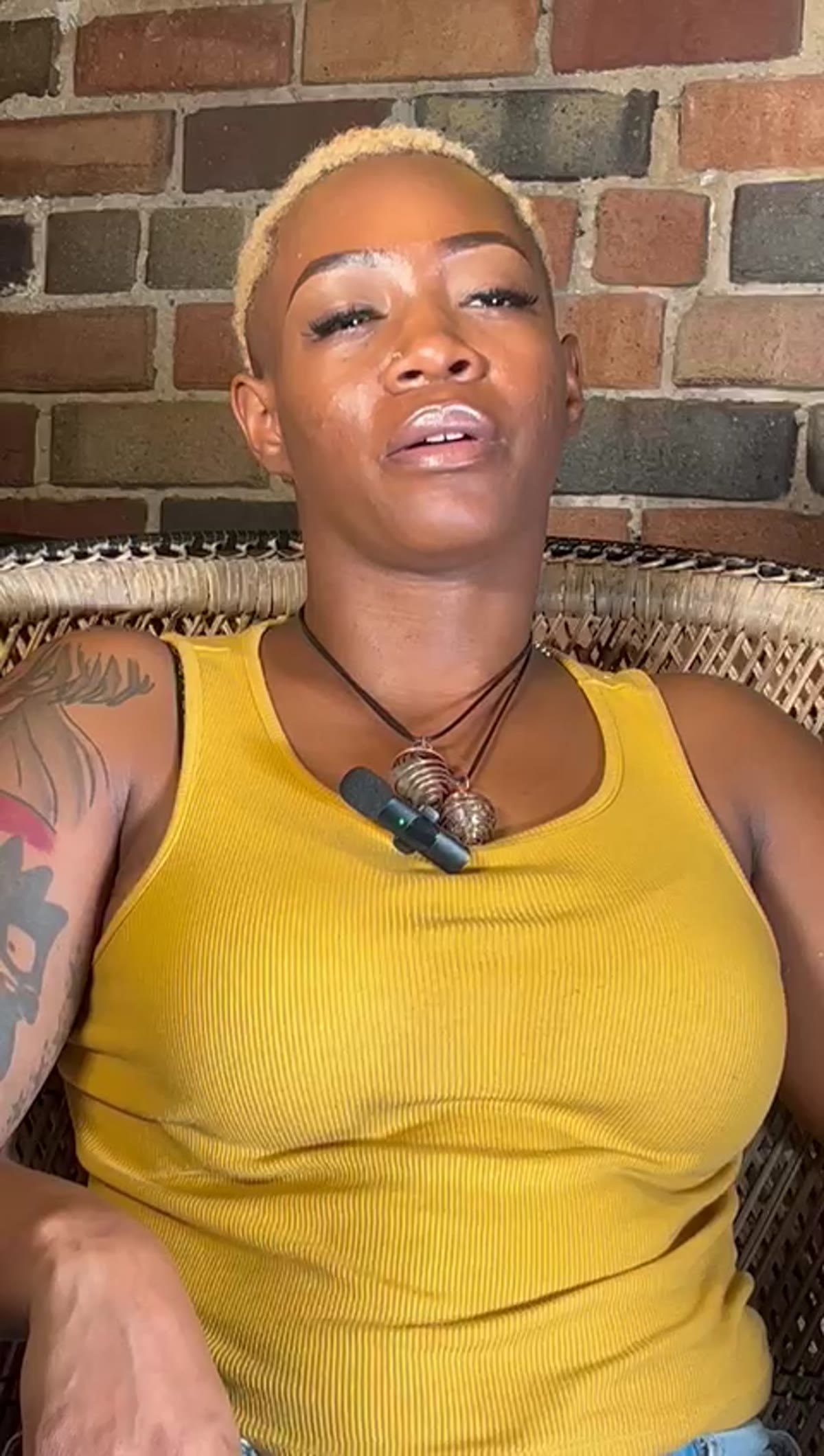 Speaker in a yellow tank, eyes closed, mid-thought.