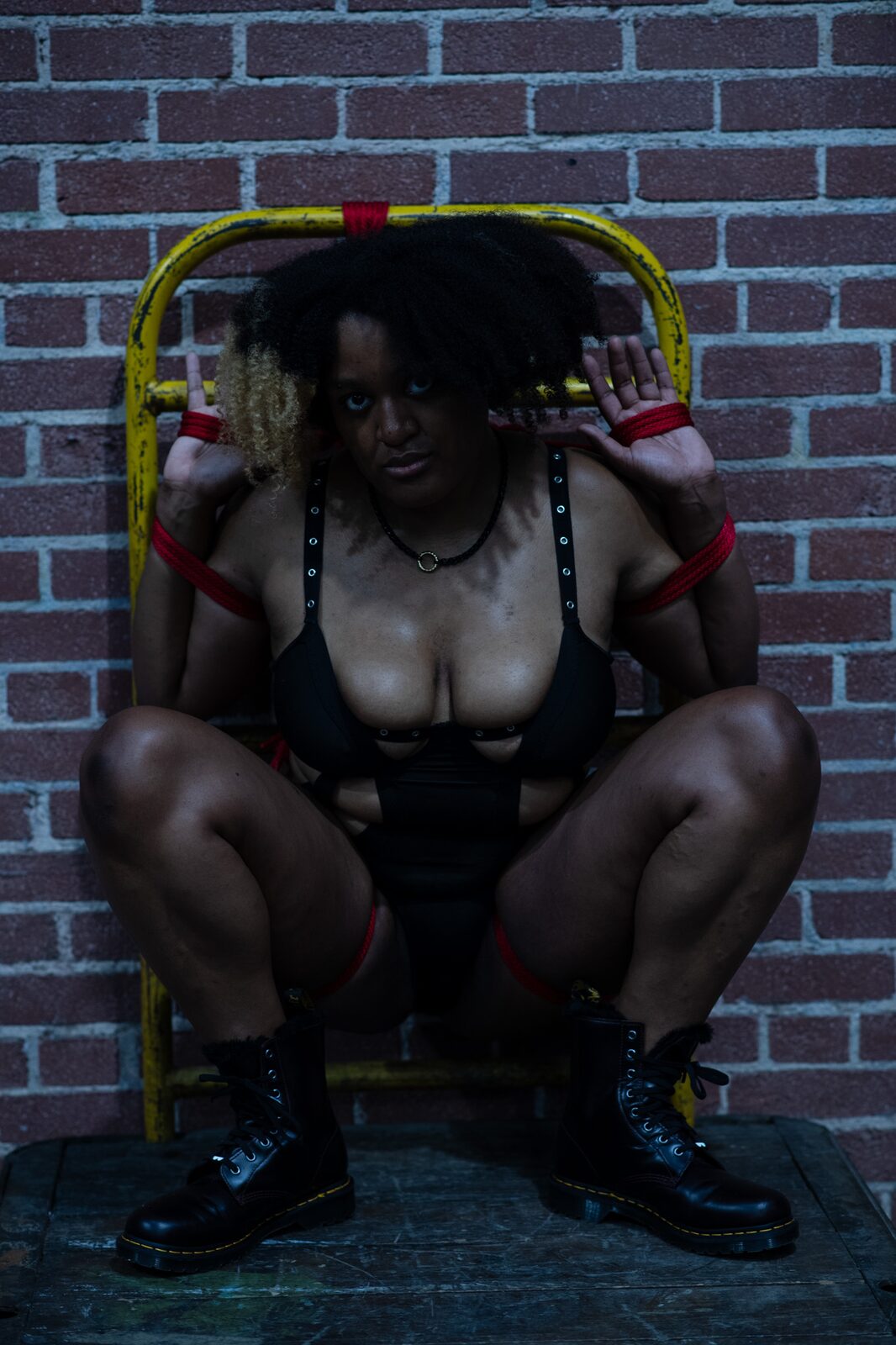 Model in rope, brick wall.