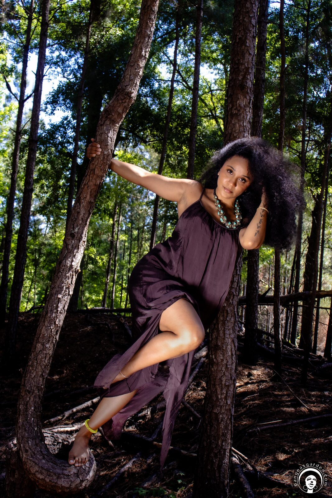 Model with sunflowers and dark robe, suspended rope above.